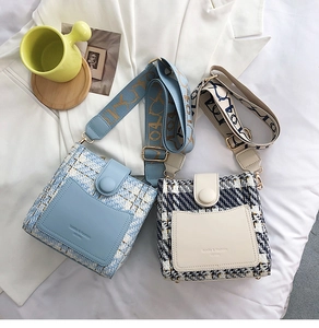 Close-up of blue and beige tweed bucket bags with wide jacquard shoulder straps
