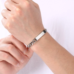Close-up of a men's stainless steel Cuban chain bracelet with a polished engravable bar