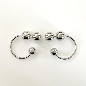 Detailed top view of silver C-shaped metallic hoop earrings with polished bead accents