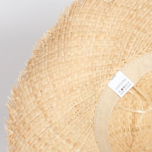Close-up of 100% natural raffia straw weave texture with sweatband and wash label