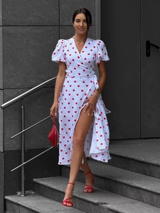 Detail of white wrap dress with red heart prints, puff sleeves and a waist tie closure
