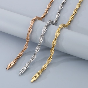 Détail macro des chaînes torsadées en or 18 carats, or rose et argent avec fermoir cliquet