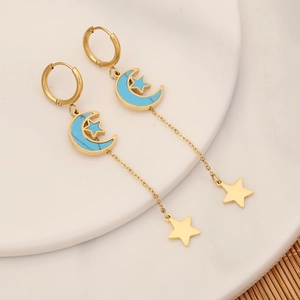 Detailed close-up of gold moon and star tassel earrings with turquoise stone inlays
