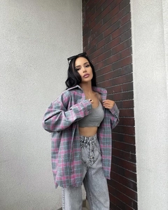 Close-up of oversized grey plaid shirt with pink accents and flannel texture details