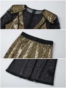 Detailed view of gold sequins and sheer black mesh fabric on a two-piece party dress