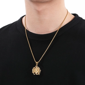 Detailed view of Medusa pendant on gold twist chain worn by a male model