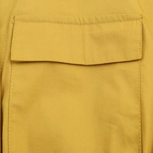 Gros plan détaillé d'une poche à rabat avec coutures sur une robe midi jaune moutarde