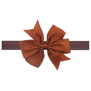 Detail of brown grosgrain ribbon bow with fine texture on elastic headband for babies