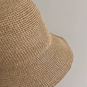 Detailed close-up of tight-knit straw texture on a minimalist khaki summer bucket hat