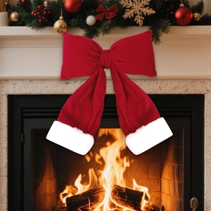 Large red velvet Christmas bow with white plush trim displayed on a festive fireplace