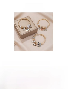 Detail of three evil eye open bracelets with colorful charms on a jewelry box surface