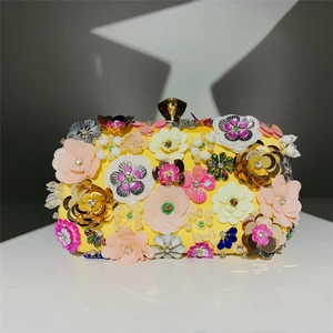 Close-up of handmade 3D floral beadwork and colorful sequins on yellow evening clutch