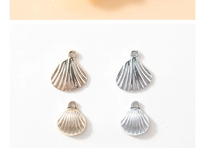 Detailed view of gold and silver shell pendants in large and small sizes on white