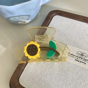 Pinza para el pelo amarilla con diseño de girasol y hojas verdes en bandeja de madera