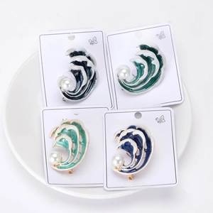 Vue détaillée de quatre broches vagues en émail avec perles sur cartes blanches