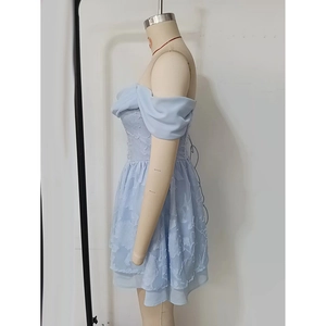 Détail de mini robe bleu clair à épaules dénudées avec broderie florale 3D et dos lacé