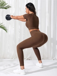 Detail of ribbed knit yoga set showing texture and stretch during squat with kettlebell