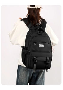 Detail view of the black multi-pocket backpack with ergonomic straps and buckle design