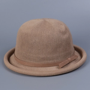 Detail of vintage knit bowler hat featuring khaki texture and a delicate ribbon bow