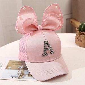 Detailed view of pink mesh baseball cap with pearl bow and rhinestone letter A decoration