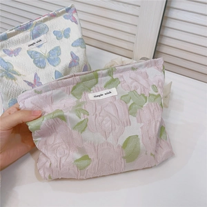 Macro detail of butterfly and rose jacquard fabric textures on small cosmetic bags