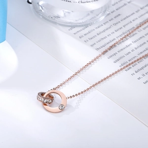 Close-up of 18k rose gold double ring necklace with sparkling rhinestone pendant