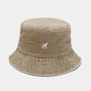 Détail d'un bob en coton lavé kaki avec broderie d'avion blanche et œillets d'aération