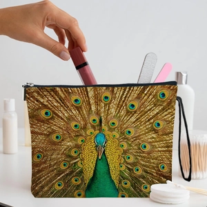 Peacock print cosmetic bag with zipper and wristlet on a minimalist vanity table