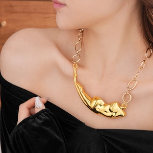 Détail du gros collier doré avec pendentif en métal liquide abstrait sur un mannequin