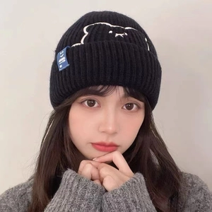 Women's black knitted beanie with cute bear embroidery and decorative blue side label