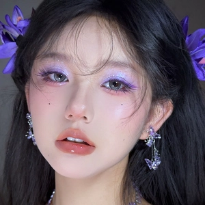 Detail von lila Kristall Schmetterling Ohrring und passendem Blumen Haarschmuck am Model