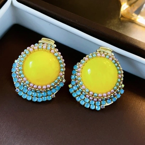 Vue macro de boucles d'oreilles fleur vintage avec pierres jaunes et perles colorées