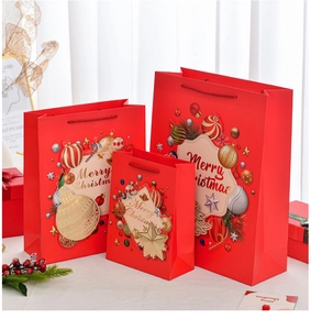 Three sizes of red festive paper gift bags with Merry Christmas text and berry decor