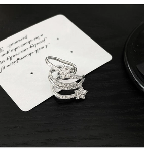 Close-up of silver multilayer star ear cuff with sparkling zircon accents on white card