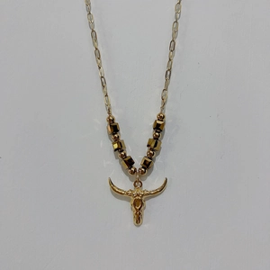 Detailed view of the gold bull skull pendant with decorative beaded chain and link necklace