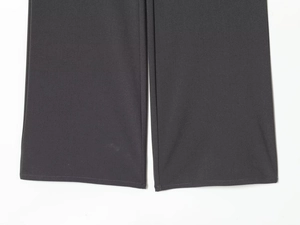 Detailed close-up of dark grey trouser leg cuffs showing smooth woven fabric and fine stitching