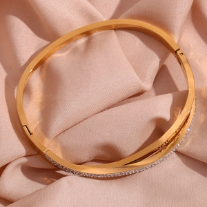 Macro shot of 18K gold plated bangle featuring crossed rows of pave set crystals