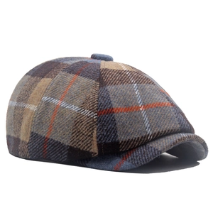 Dettaglio del cappello newsboy in misto lana con motivo scozzese vintage blu e marrone