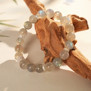 Macro shot of labradorite beaded bracelet with blue sheen on vintage wood background