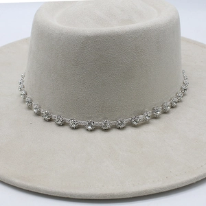 Detail of light beige felt fedora hat featuring a sparkling rhinestone chain decoration