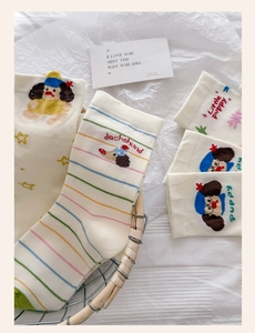 Detailed view of knitted cotton socks with dachshund embroidery and colorful stripes