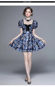 Detail of blue printed dress with black lace neckline and decorative bow detail