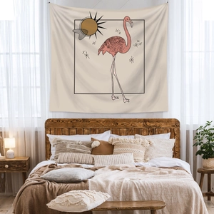 Detail of bohemian wall tapestry featuring a pink flamingo and sun on beige fabric