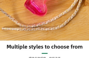 Macro shot of pink heart-shaped glass perfume bottle with decorative gold woven cord
