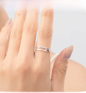 Macro detail of minimalist S925 sterling silver double-layered twist ring on finger