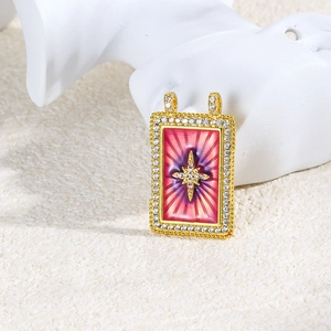 Macro shot of gold tarot pendant with pink gradient enamel and sparkling star detail