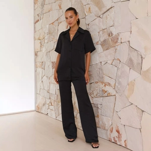 Detail of black satin lounge set showing lapel button shirt and wide-leg trousers
