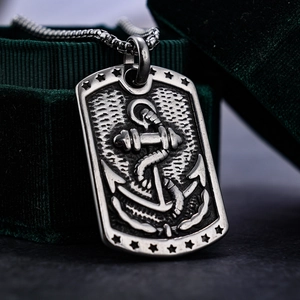 Vintage stainless steel anchor pendant necklace with engraved stars on a green velvet box