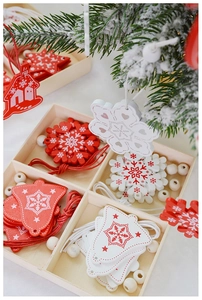 Detailed close-up of red and white wooden Christmas ornaments in a grid box with rustic twine