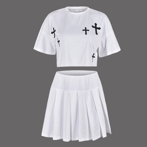 Dettaglio completo del set bianco due pezzi con crop top croce nera e minigonna a pieghe